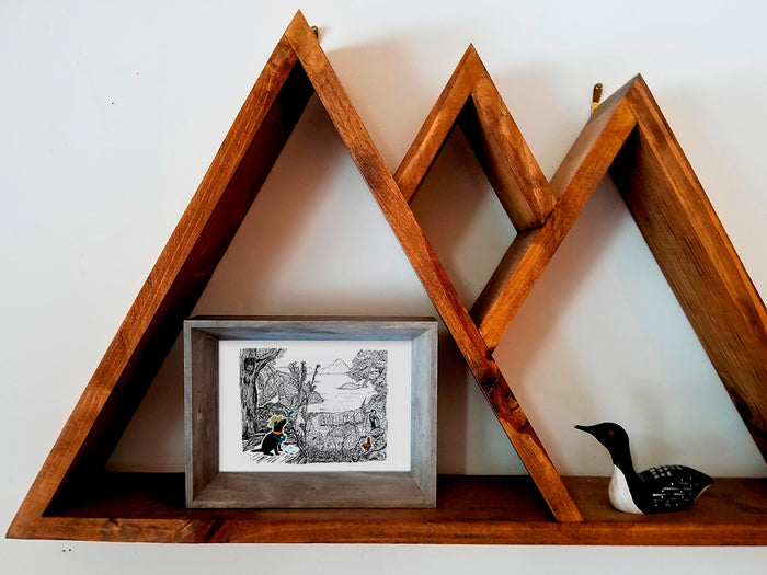 Framed illustration of a dog in a forest among birds on a wood shelf.
