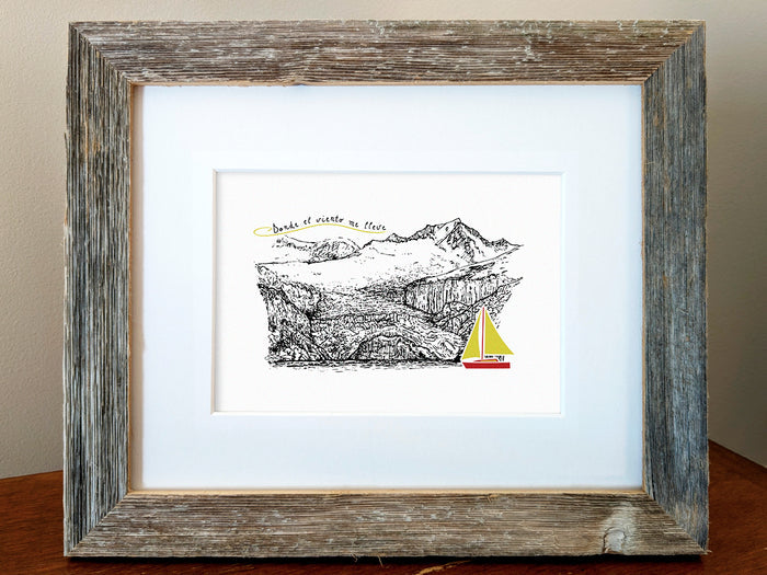 Framed art print of a red and yellow sailboat with mountains in the background and the text Donde el viento me lleve.