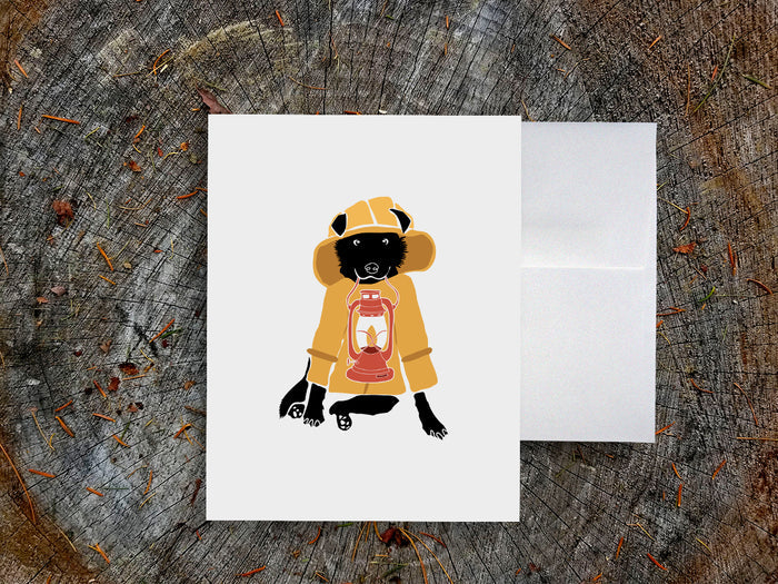 Greeting card with image of a dog with a yellow fisherman jacket holding a lantern.