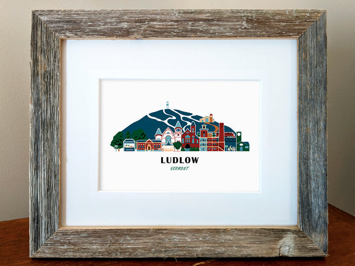 Framed art print of buildings arranged in a skyline with the text Ludlow Vermont