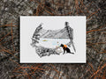 Illustration of a dog painting in front of a lake on a wood surface.