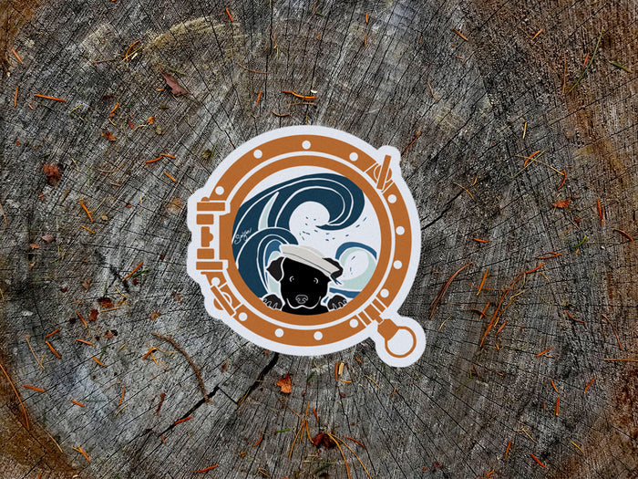 Sticker with a design of a dog and waves  looking through a porthole on a wooden background