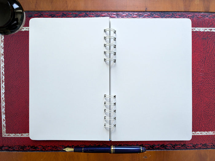 Open notebook with a pen on a decorative surface